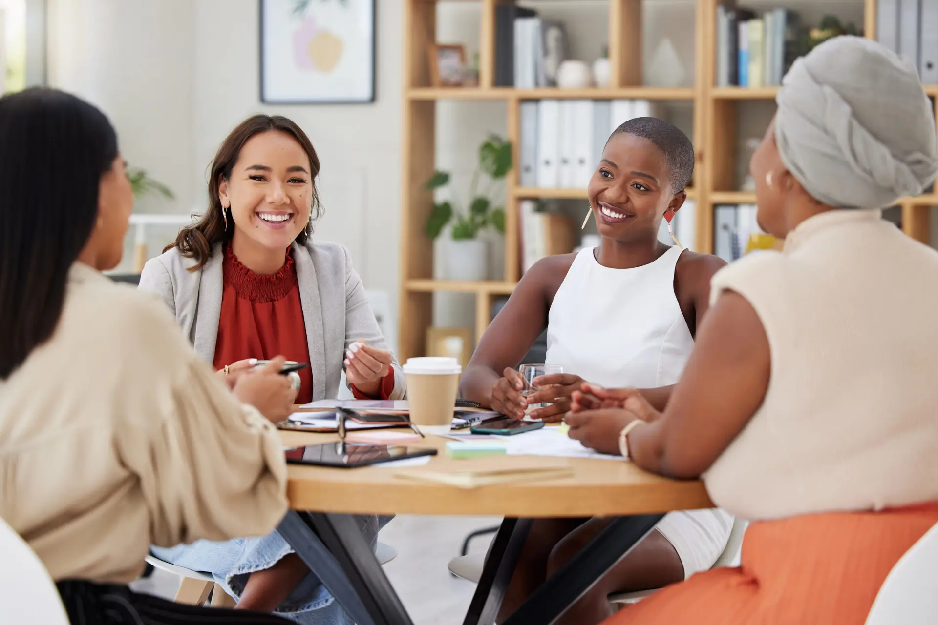 Diverse group of smiling business women having a brainstorm meeting in office. Happy confident prof.